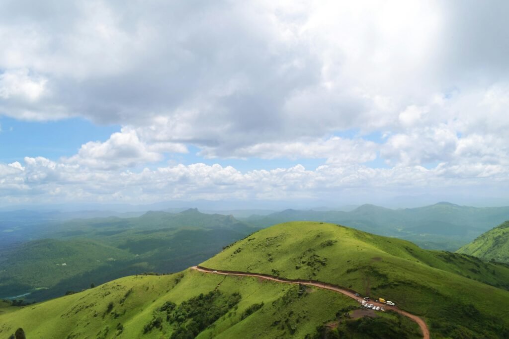 Panoramic view of green hills and cloudy sky in Chikmagalur, India, showcasing natural beauty and serene landscapes.