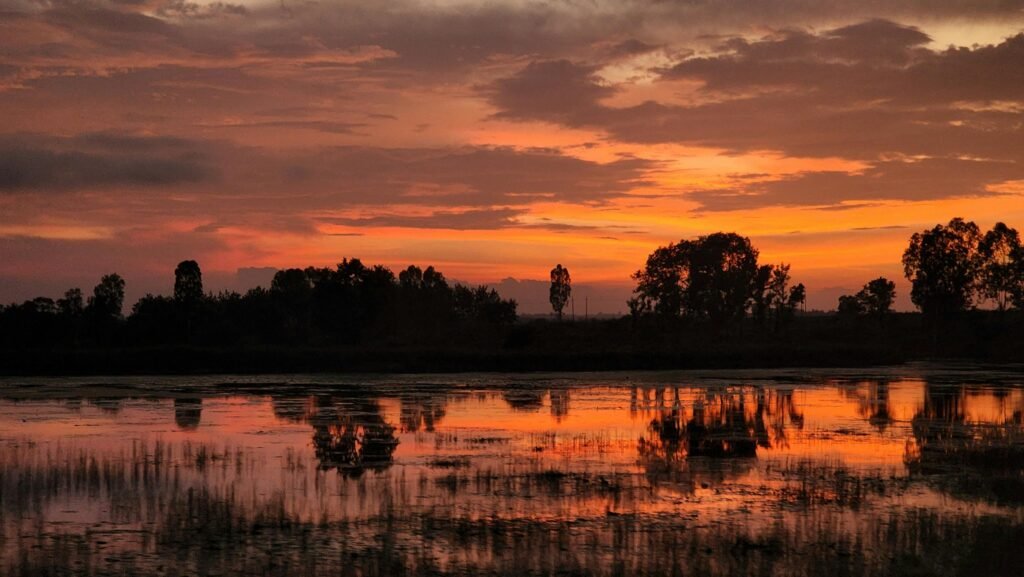 Beautiful sunset scene with reflections on water in Madikeri, India.
